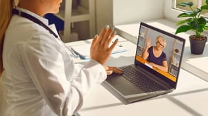 Doctor conducting an online consultation with a patient via laptop